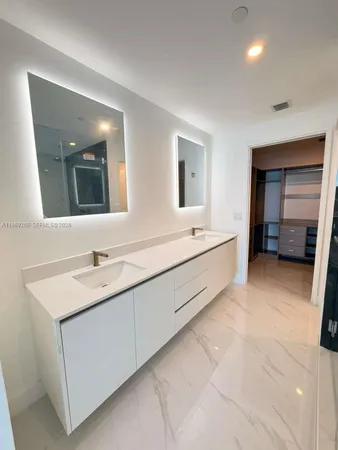a spacious bathroom with a double vanity sink and mirror