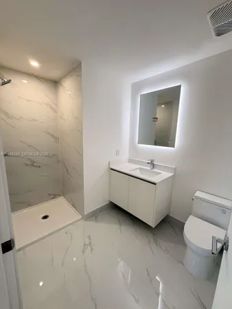 a bathroom with a bathtub sink mirror and toilet