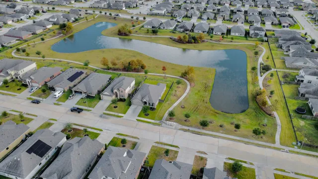an aerial view of a swimming pool with outdoor seating and yard