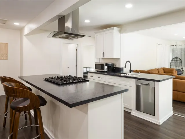 a kitchen with stainless steel appliances granite countertop a stove a sink and a refrigerator