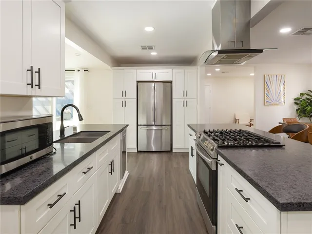 a kitchen with stainless steel appliances granite countertop a sink stove and refrigerator