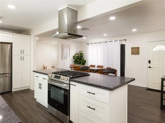 a kitchen with stainless steel appliances granite countertop a stove a sink and a refrigerator