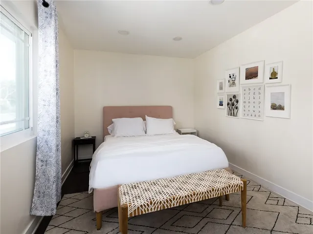 a large bed sitting in a bedroom next to a window