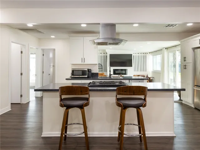 a kitchen with stainless steel appliances a stove a sink a refrigerator and a microwave