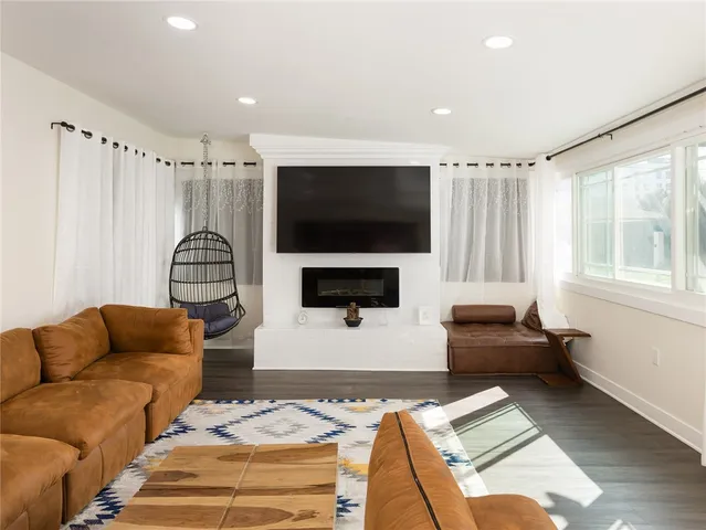 a living room with furniture a flat screen tv and a window