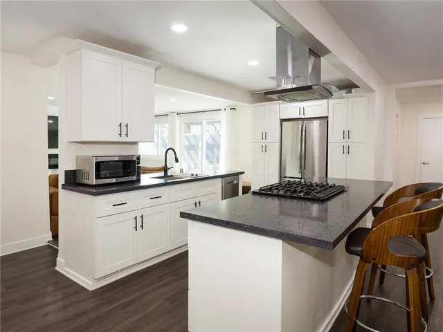 a kitchen with stainless steel appliances granite countertop a sink stove and cabinets