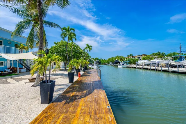 a balcony with wooden floor outdoor seating and yard in the back