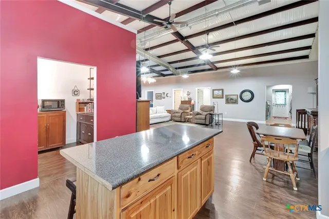 a kitchen with stainless steel appliances granite countertop a sink dishwasher and a dining table with chairs