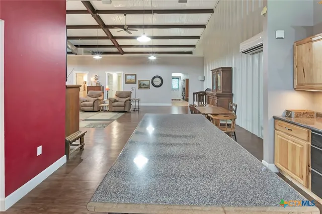 a view of a kitchen with kitchen island stainless steel appliances a stove a sink and a refrigerator