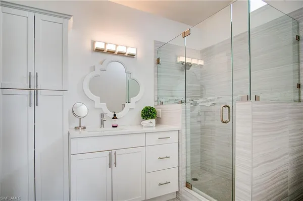 a bathroom with a tub a sink and a mirror
