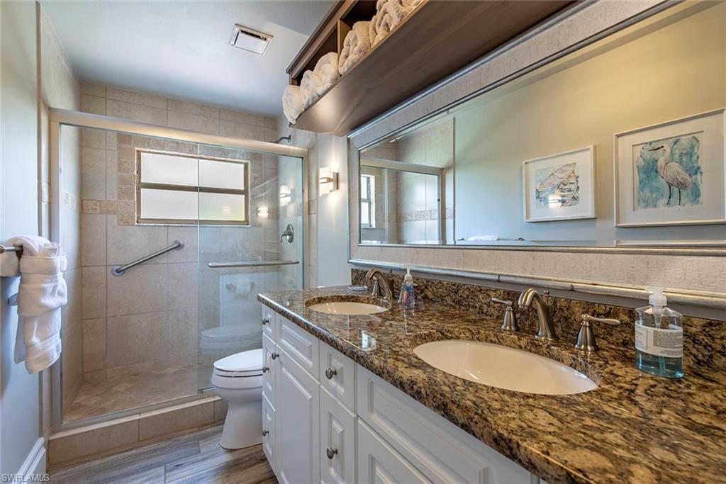 7271 Mill Pond Circle Naples, FL 34109 - Photo 16 of 45 a bathroom with a granite countertop sink and a mirror