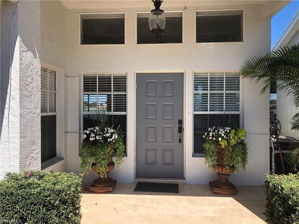 7271 Mill Pond Circle Naples, FL 34109 - Photo 20 of 45 a potted plant sitting in front of a house