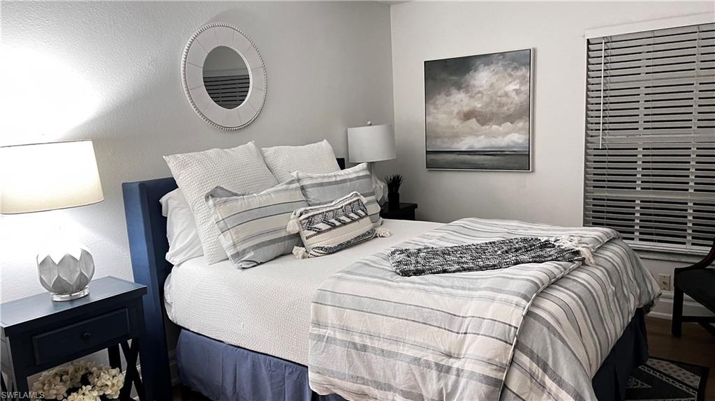 7271 Mill Pond Circle Naples, FL 34109 - Photo 36 of 45 a bedroom with a bed and a painting on the wall