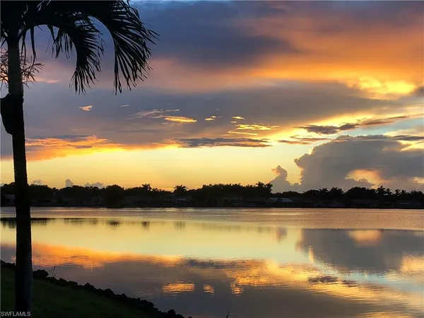 a living room with furniture a large window and a chandelier