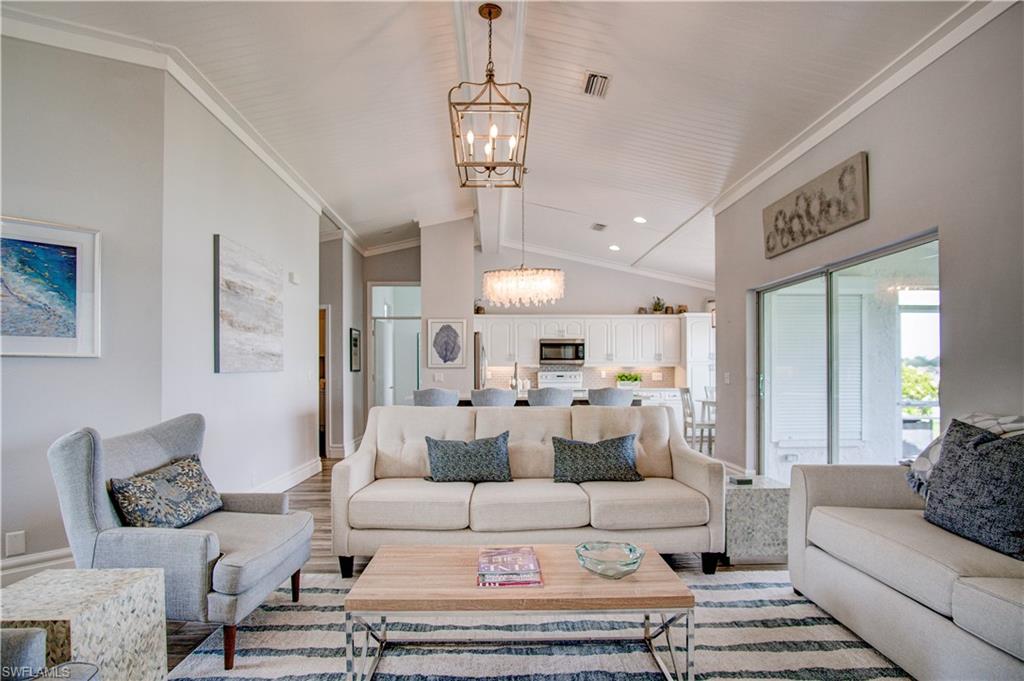7271 Mill Pond Circle Naples, FL 34109 - Photo 45 of 45 a living room with furniture a large window and a chandelier