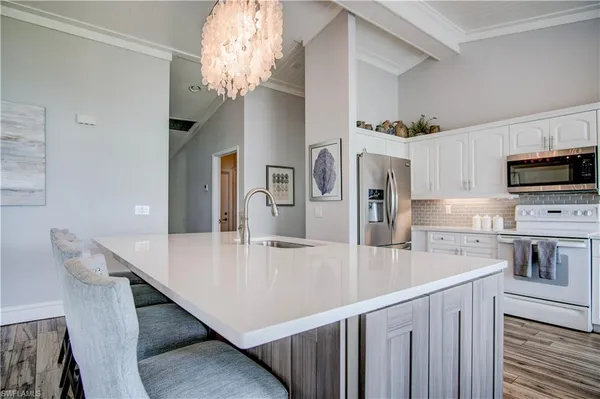 a kitchen with cabinets stainless steel appliances and wooden floors