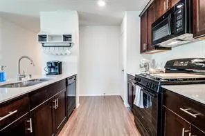 a kitchen with a sink a stove and cabinets