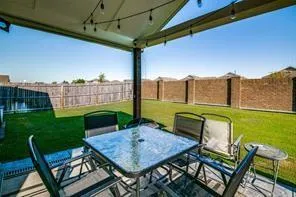 a view of a patio with table and chairs and a barbeque