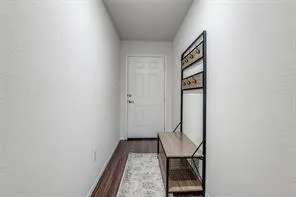 a view of a hallway with wooden floor and entryway