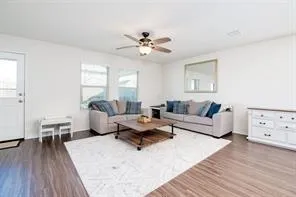 a living room with furniture and a wooden floor