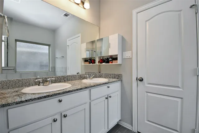 a bathroom with a granite countertop sink and a mirror