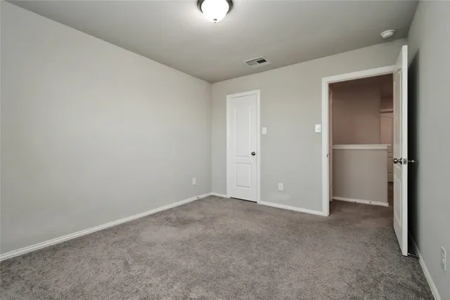 an empty room with closet area and windows