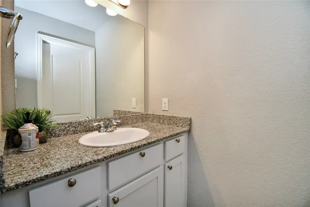 a bathroom with a granite countertop sink and a mirror