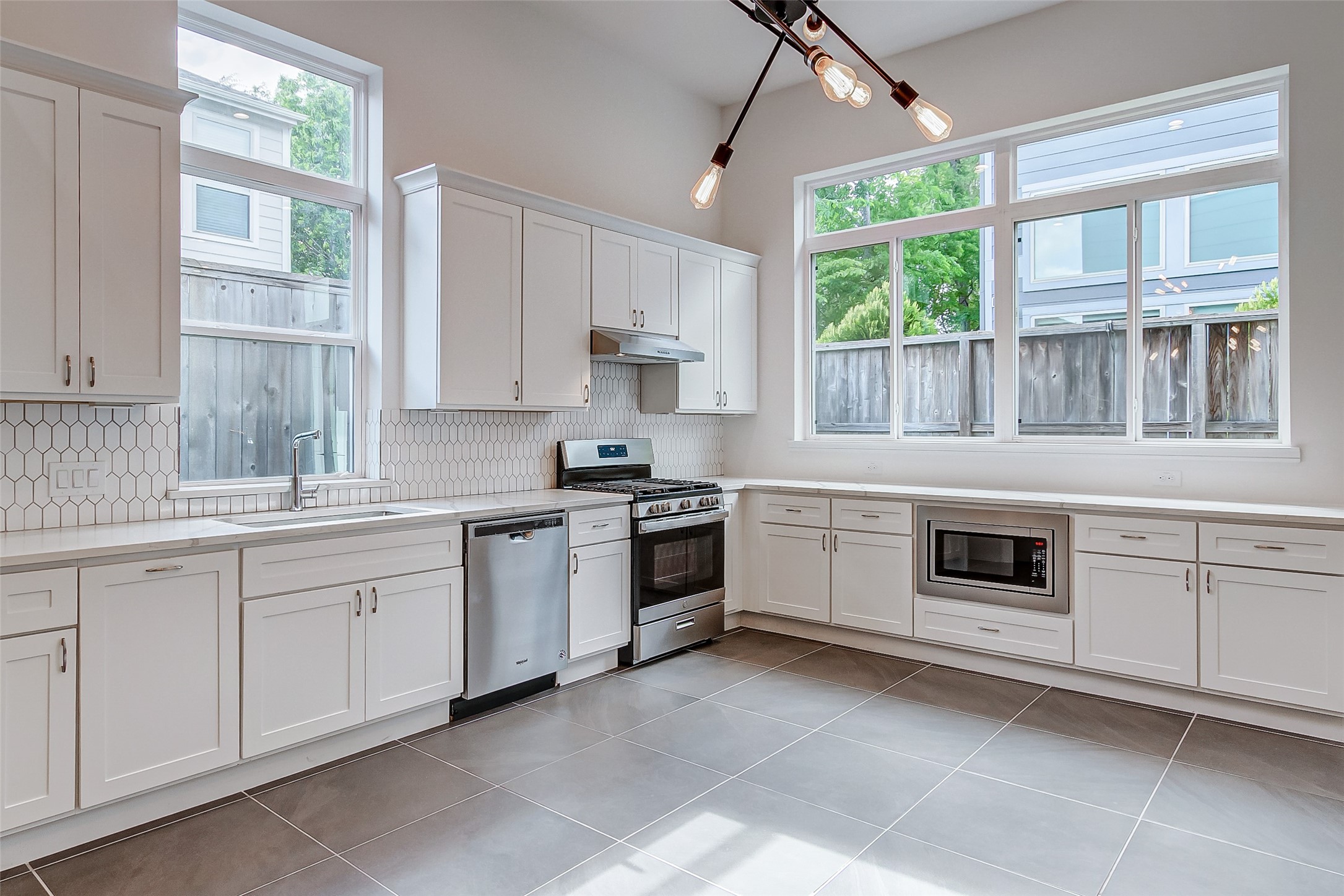 8926 Spring Knoll Forest Drive Houston, TX 77080 - Photo 5 of 22 a kitchen with granite countertop white cabinets and a stove