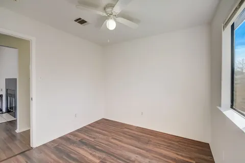 an empty room with a window and wooden floor