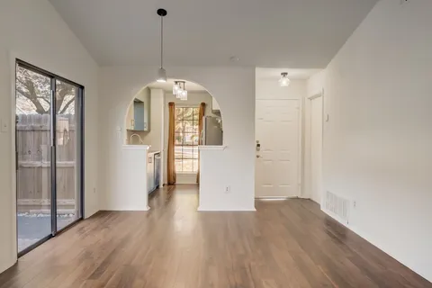 a view of a room with wooden floor mirror and windows