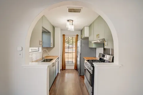 a kitchen with stainless steel appliances a sink stove and refrigerator