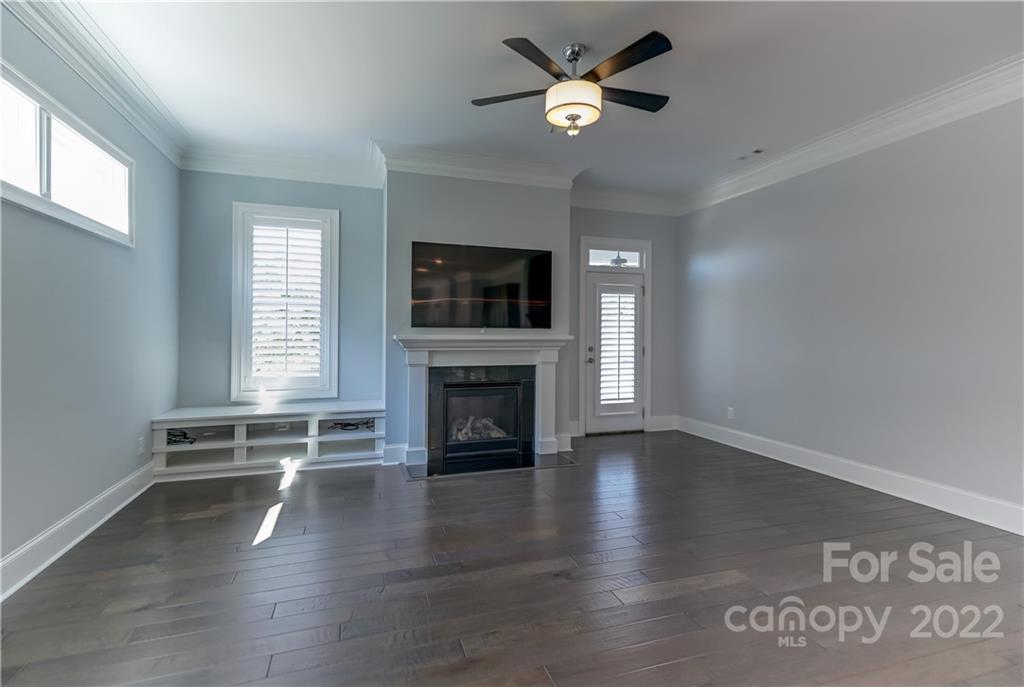 320 Sensibility Circle Fort Mill, SC 29708 - Photo 19 of 48 an empty room with windows fireplace and a ceiling fan