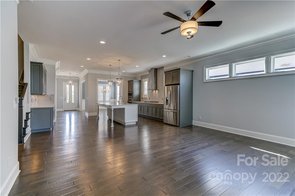 320 Sensibility Circle Fort Mill, SC 29708 - Photo 21 of 48 a view of an empty room with wooden floor and a kitchen