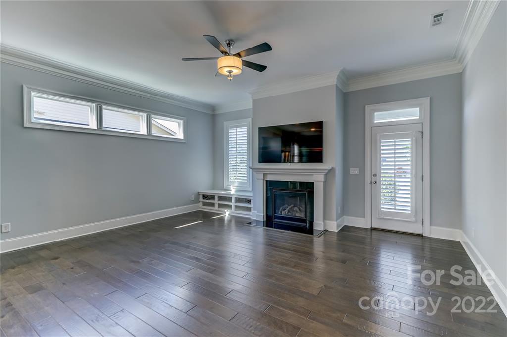 320 Sensibility Circle Fort Mill, SC 29708 - Photo 22 of 48 an empty room with wooden floor fireplace and windows
