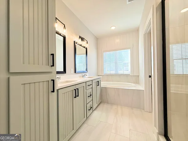 a bathroom with a tub sink and mirror