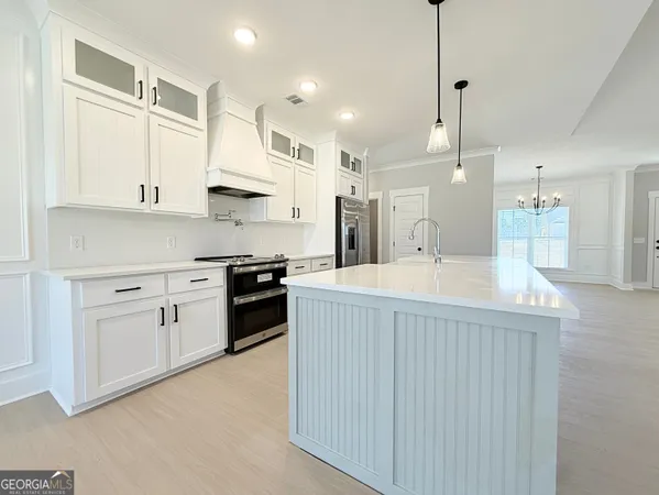 a kitchen with stainless steel appliances kitchen island a sink stove and cabinets