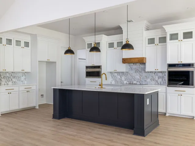 a kitchen with stainless steel appliances granite countertop a sink and cabinets
