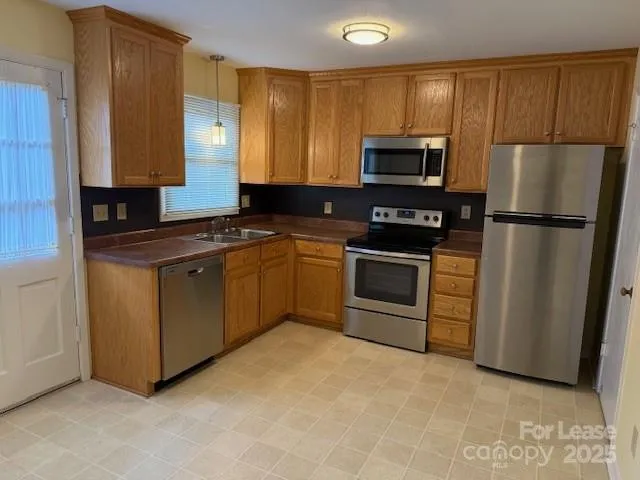 a kitchen with stainless steel appliances granite countertop a stove a refrigerator and a sink