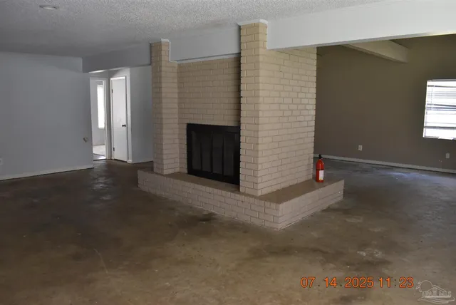 a view of a livingroom with an empty space and a fireplace