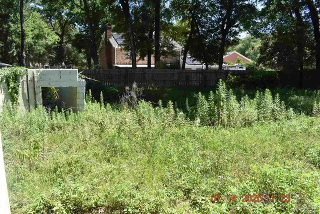 a front view of a house with a yard and potted plants