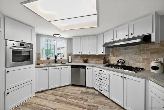 a kitchen with white cabinets and appliances