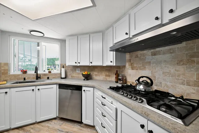 a kitchen with sink a stove and cabinets