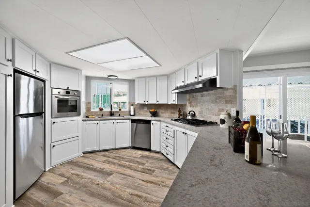 a kitchen with granite countertop a refrigerator stove top oven and sink