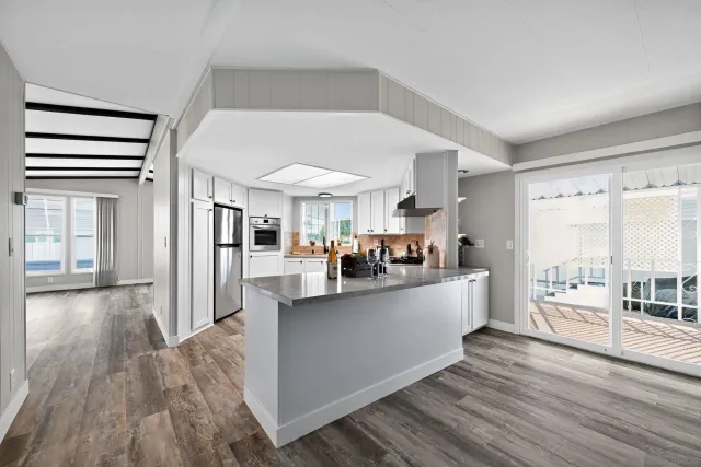 a view of living room kitchen with furniture and wooden floor
