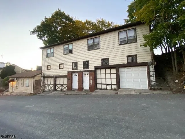 a view of white house with large windows and a small yard