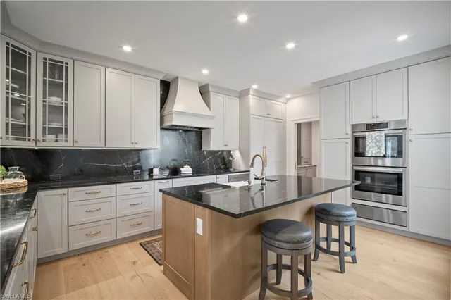 a kitchen with stainless steel appliances granite countertop a stove refrigerator sink and cabinets