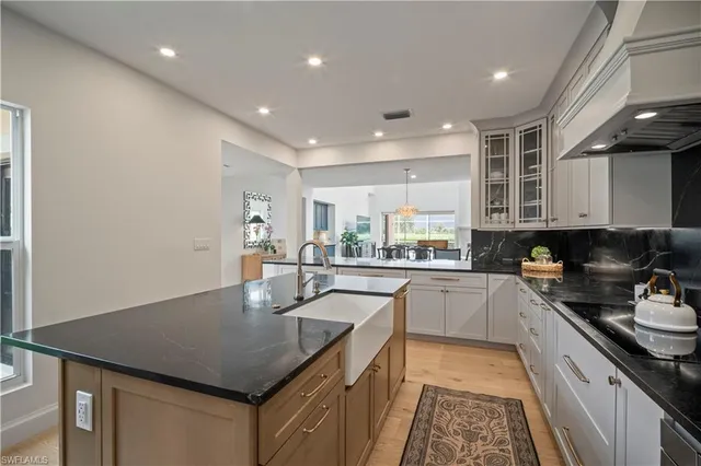 a kitchen with stainless steel appliances granite countertop a sink dishwasher a stove and a refrigerator with wooden floor