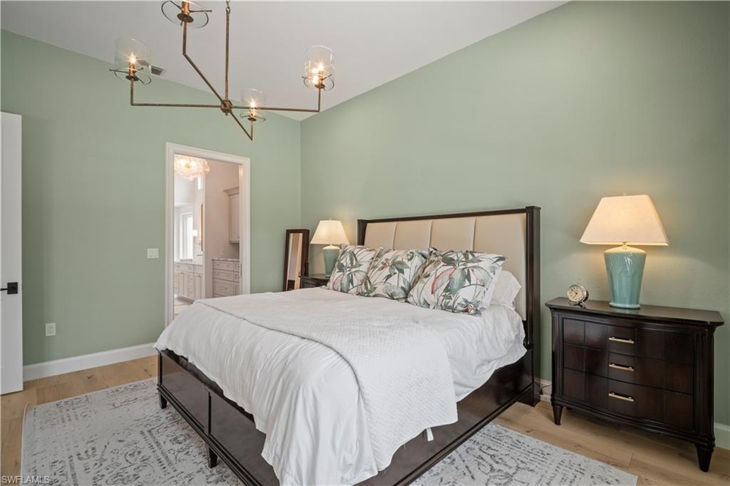 11448 Quail Village Way Naples, FL 34119 - Photo 23 of 41 a bedroom with a bed and a lamp