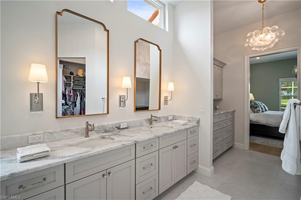 11448 Quail Village Way Naples, FL 34119 - Photo 24 of 41 a en suite bathroom with a double vanity sink and a mirror