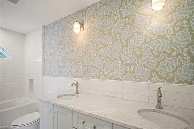 a bathroom with a granite countertop sink toilet and a bathtub